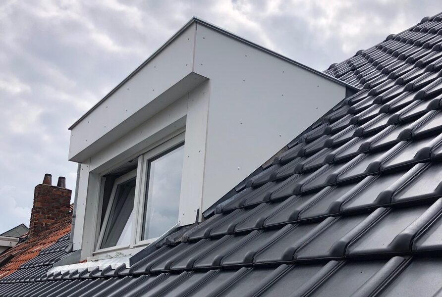 Moderne dakkapel op een hellend dak met nieuwe dakbedekking en een groot raam voor extra licht en ruimte