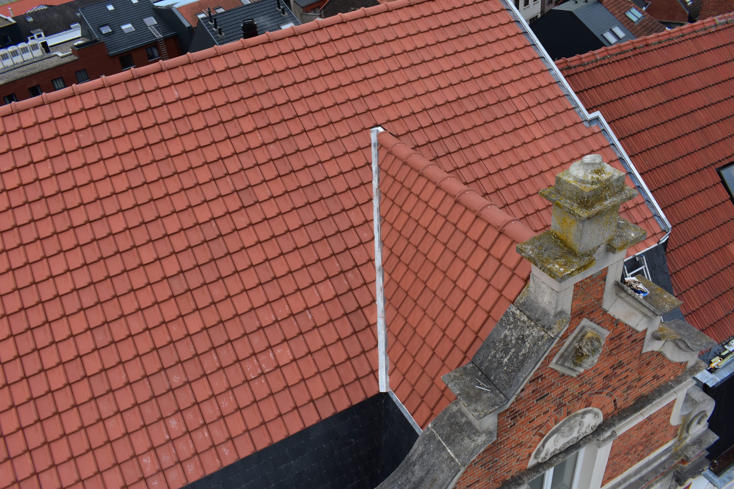 Hersteld rood pannendak met zinkwerk rond de schoorsteen