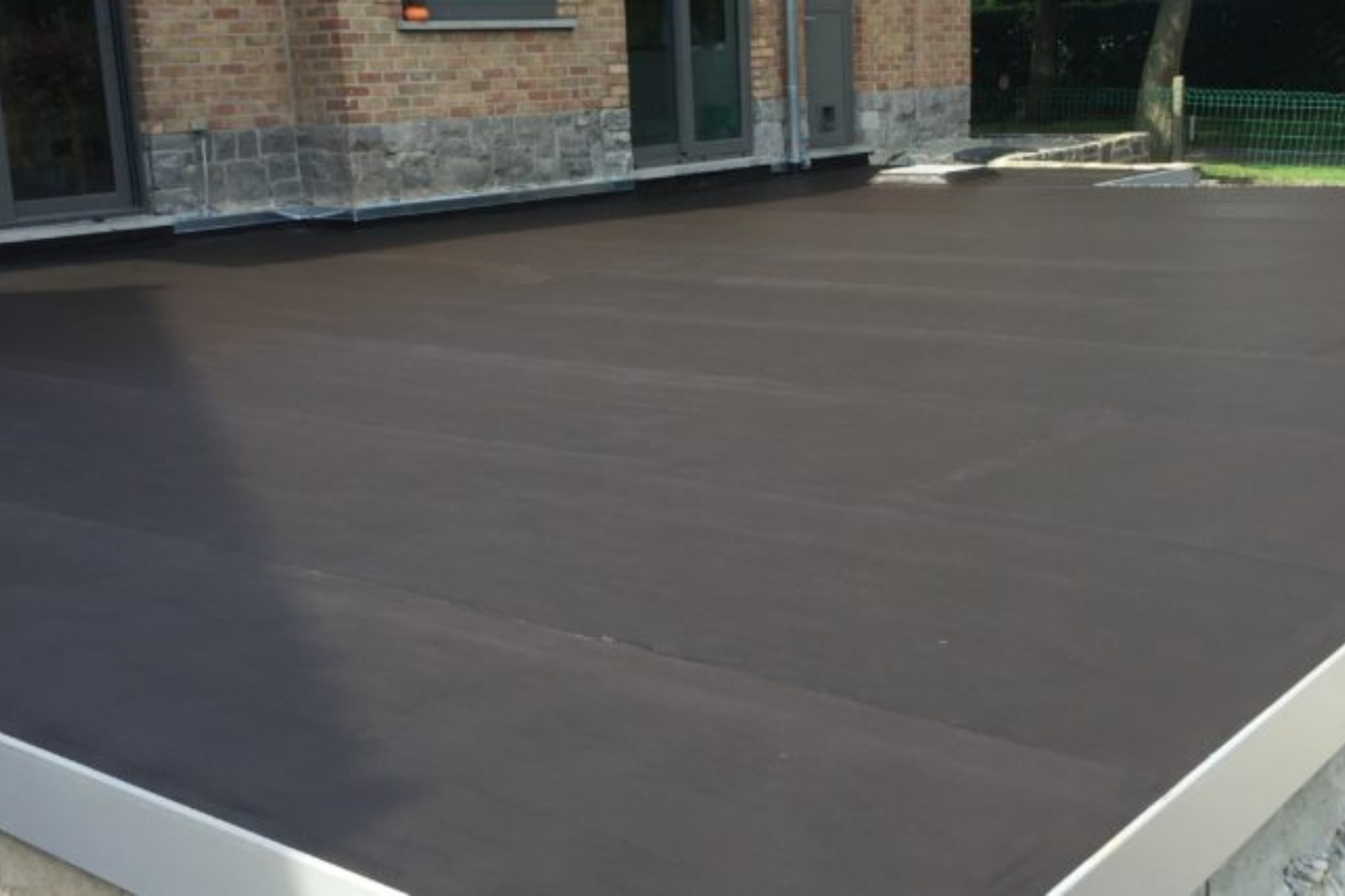 Onderhouden plat dak met waterdichte dakbedekking na professionele inspectie en reiniging.