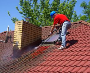 Dakwerken die dak aan het onderhouden is