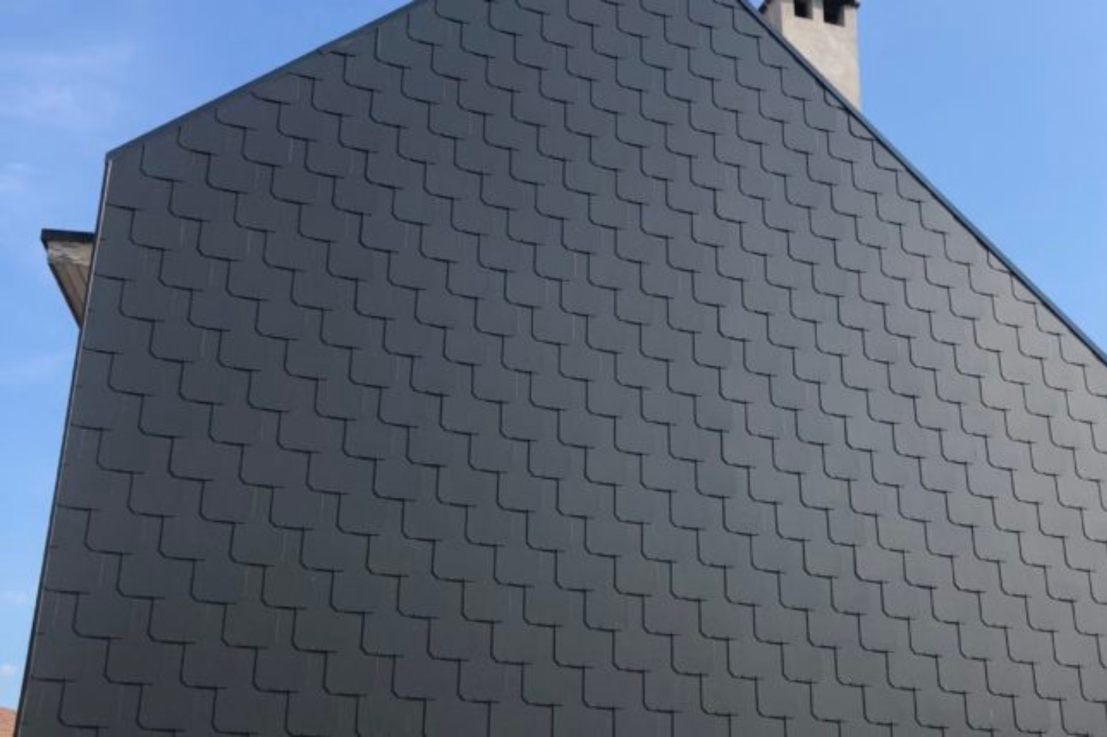 Gevelbekleding met antraciet kunstleien in visschubpatroon geplaatst door Dakwerken Van Driessche