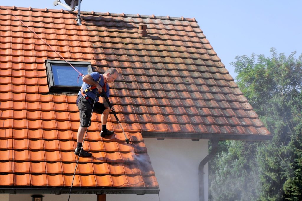 hellend dak onderhoud met dakpannen reinigen en mos verwijderen