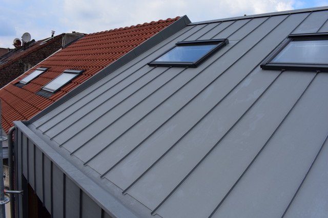 Hellend dak afgewerkt met grijs zink en ingewerkte dakramen