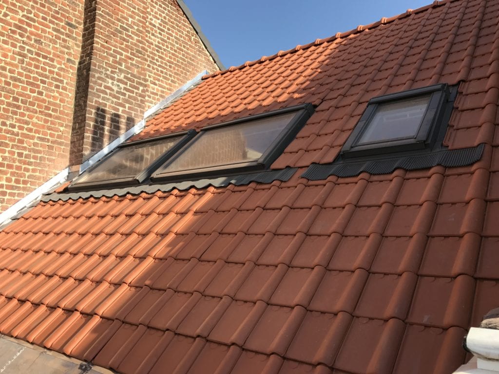 Gekoppelde dakramen geplaatst in een rood pannendak op een hellend dak